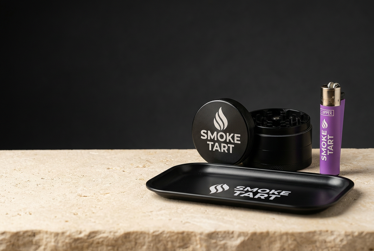 SmokeTart custom-engraved grinders, rolling tray and Clipper lighters arranged in a premium studio photo